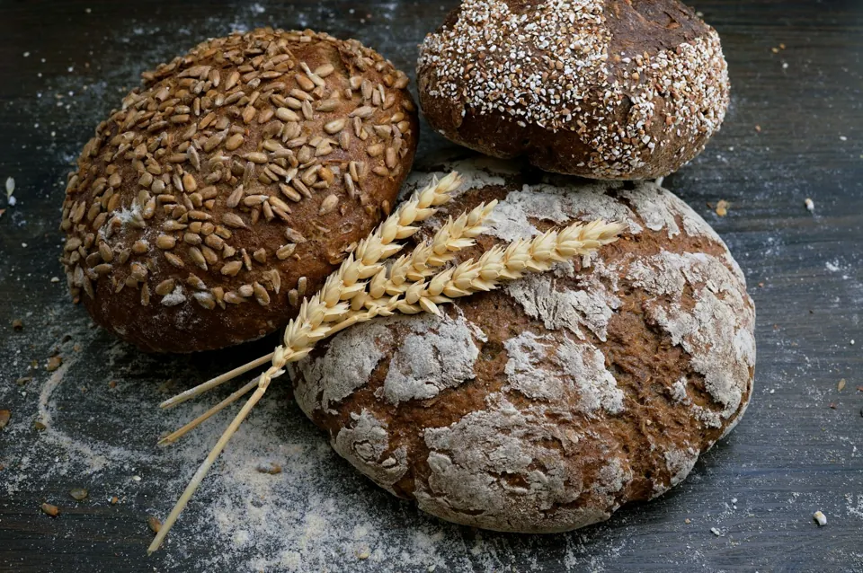 Golden loaves resting on a flour-dusted table