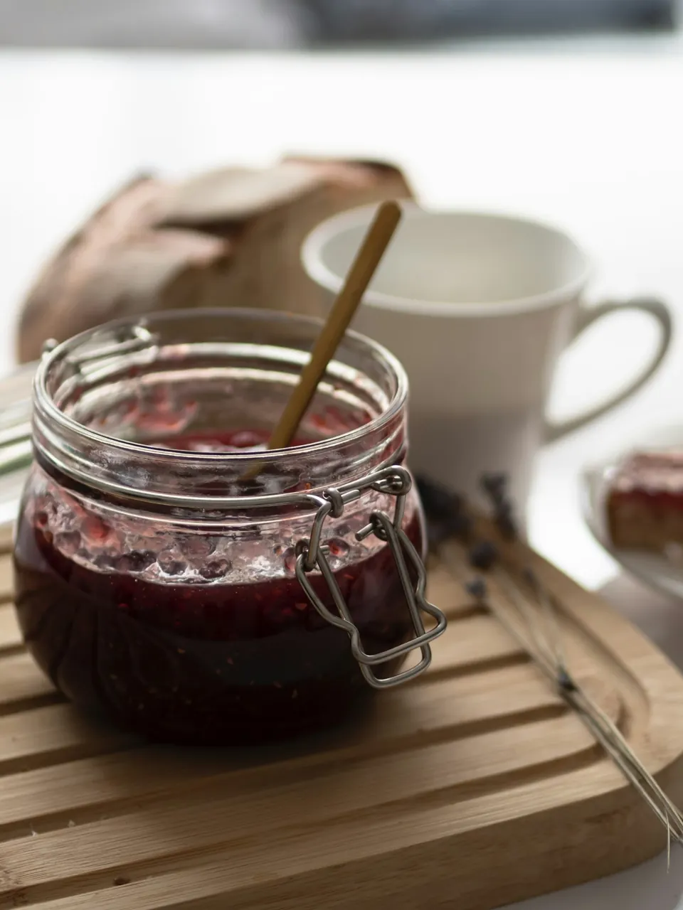 Fruit preserves in an open glass jar with a spoon