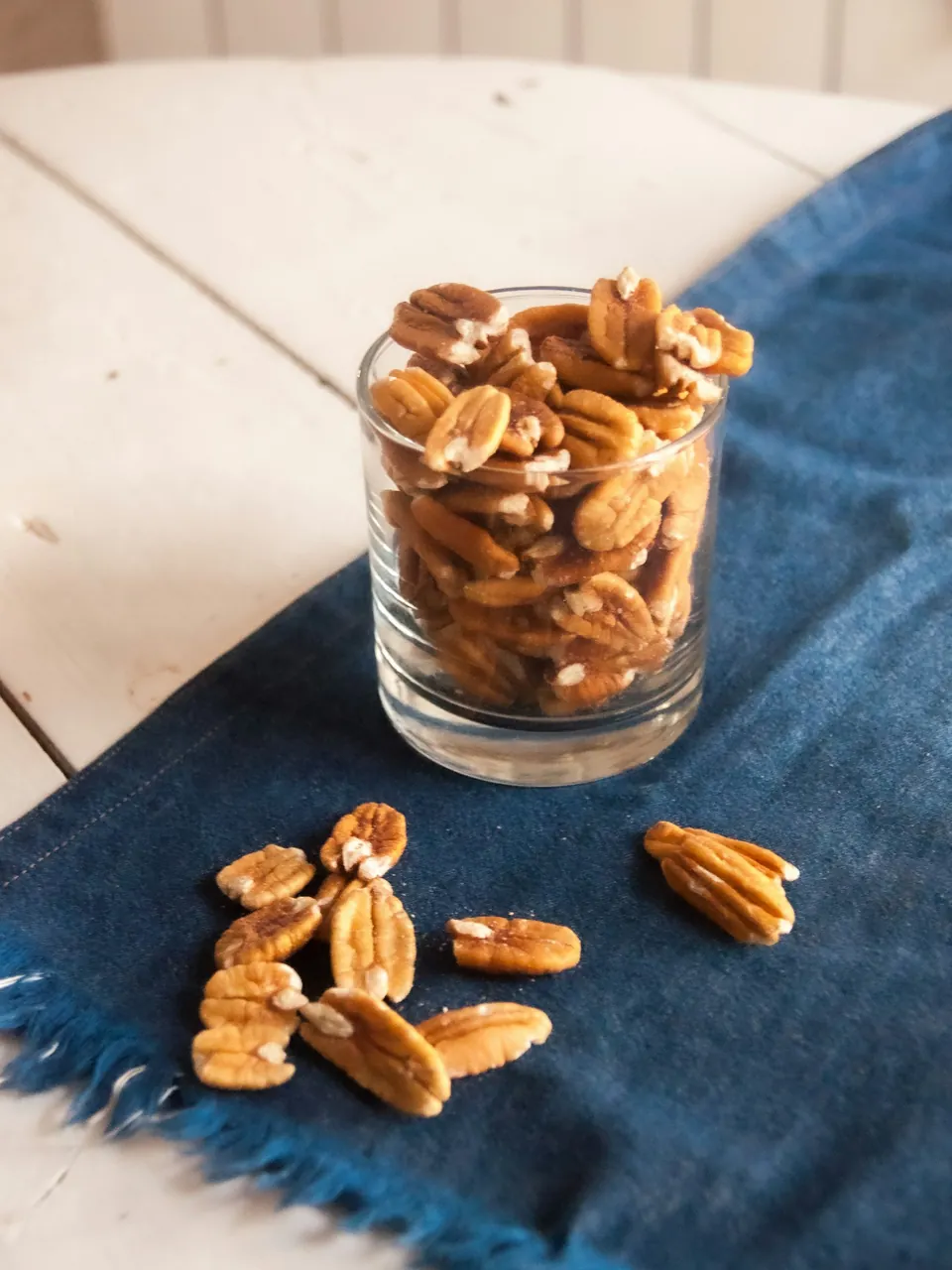 A jar of golden candied pecans in the afternoon light